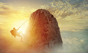 A Mountain Climber About To Reach The Top Of A Mountain Peak In Front Of A A Mountain Climber About To Reach The Top Of A Mountain Peak In Front Of A