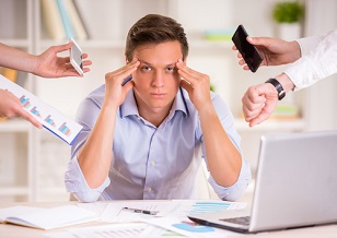 Stressed manager in his office being asked to do too many tasks at once
