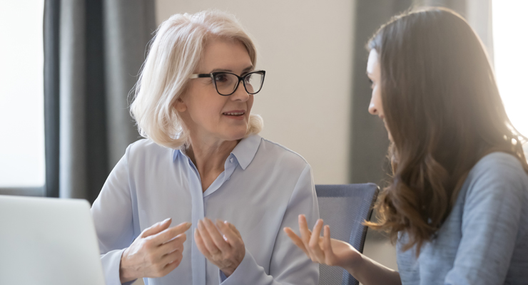 Older professional woman coaching younger professional woman