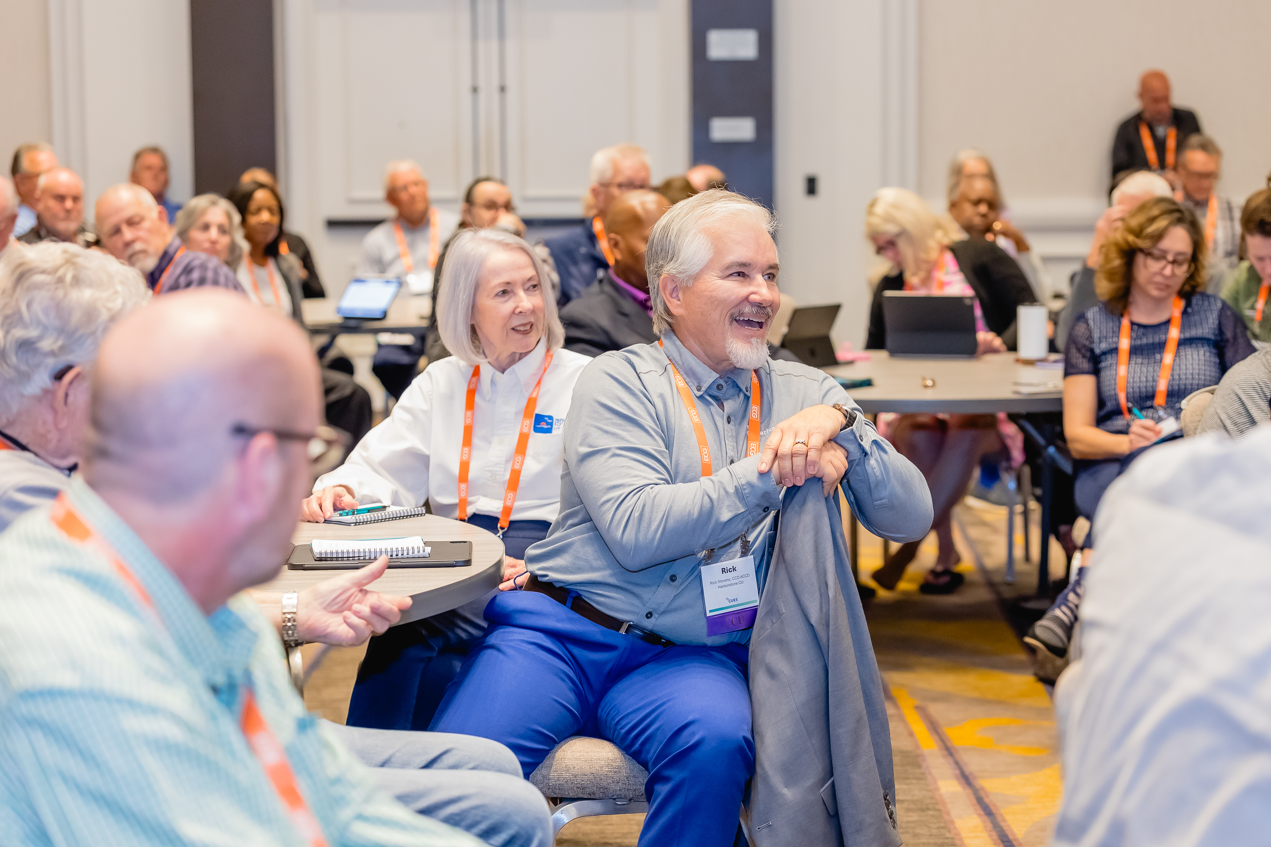 Man leaning forward listening to speaker at conference