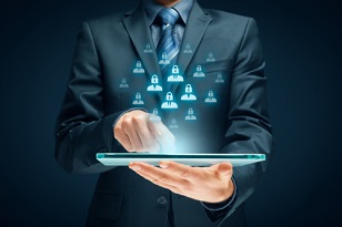 Man holding a tablet with icons of people hovering over it, technological-looking