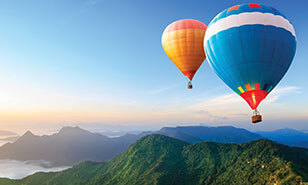 colorful hot air balloons soaring over mountains