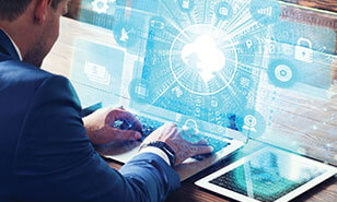 Young businessman working on his laptop in the office, select the icon cloud service on the virtual display.