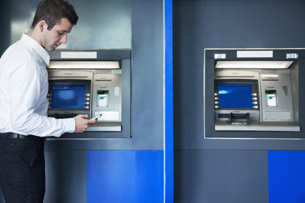 man standing at ATM